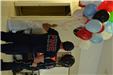 firefighter holding red, white, blue, and black balloons