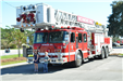 two children standing under fire truck ladder