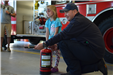 firefighter demonstrates use of fire extinguisher