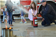 firefighter demonstrates use of fire extinguisher