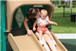 mom slides down slide with toddler in her lap