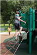 boy climbs on playground equipment