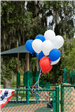 red white and blue balloons tied to playground fence