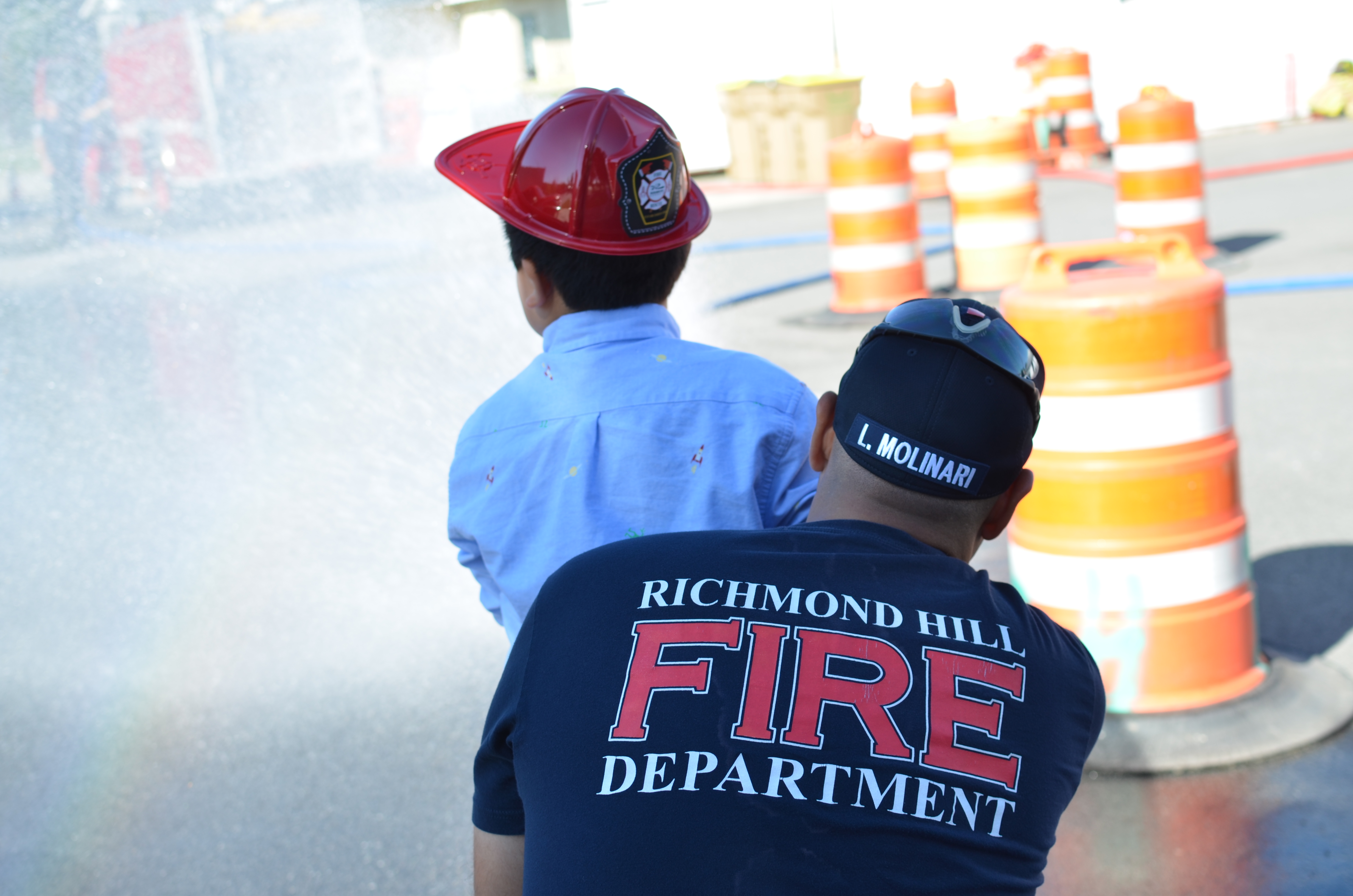 Water from fire hose hitting construction barrels