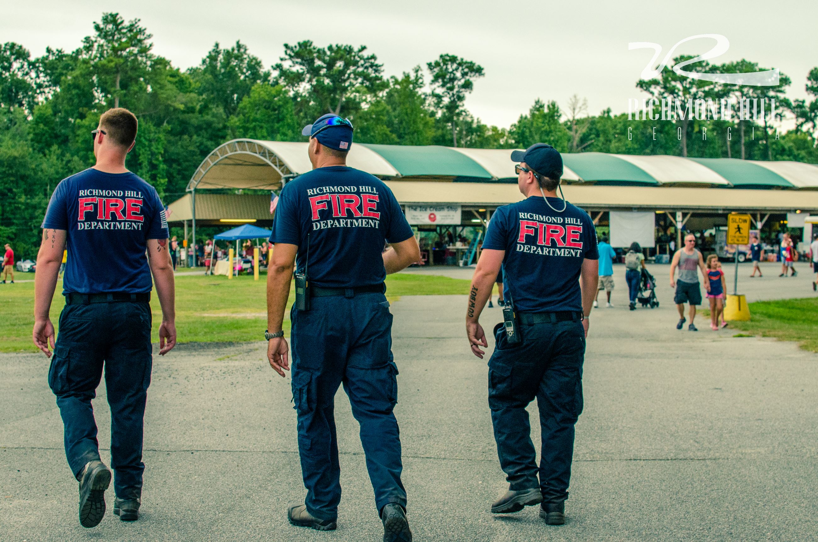 three Richmond Hill Firefighters walk through J F Gregory Park
