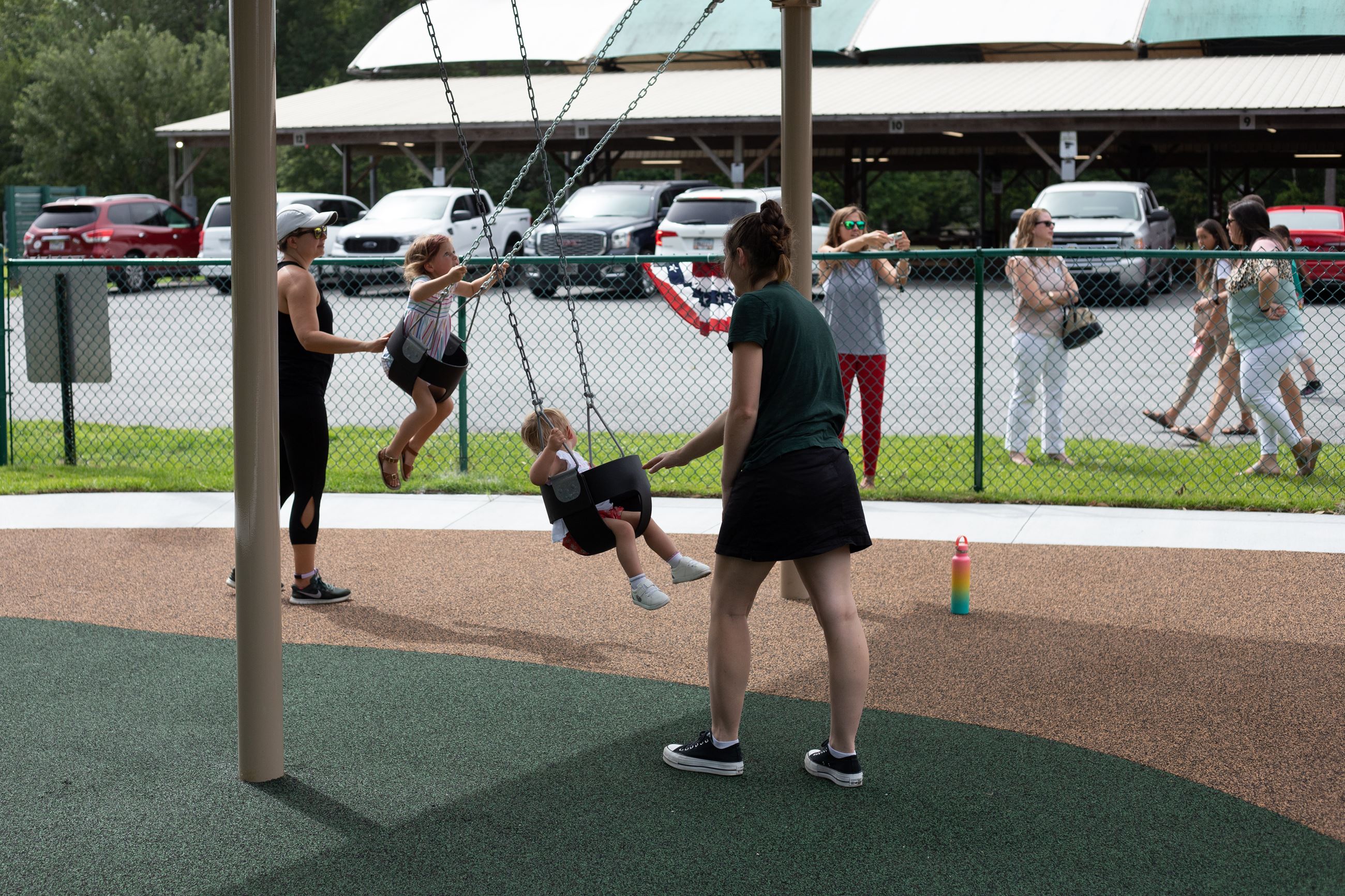mom watching child on park swings